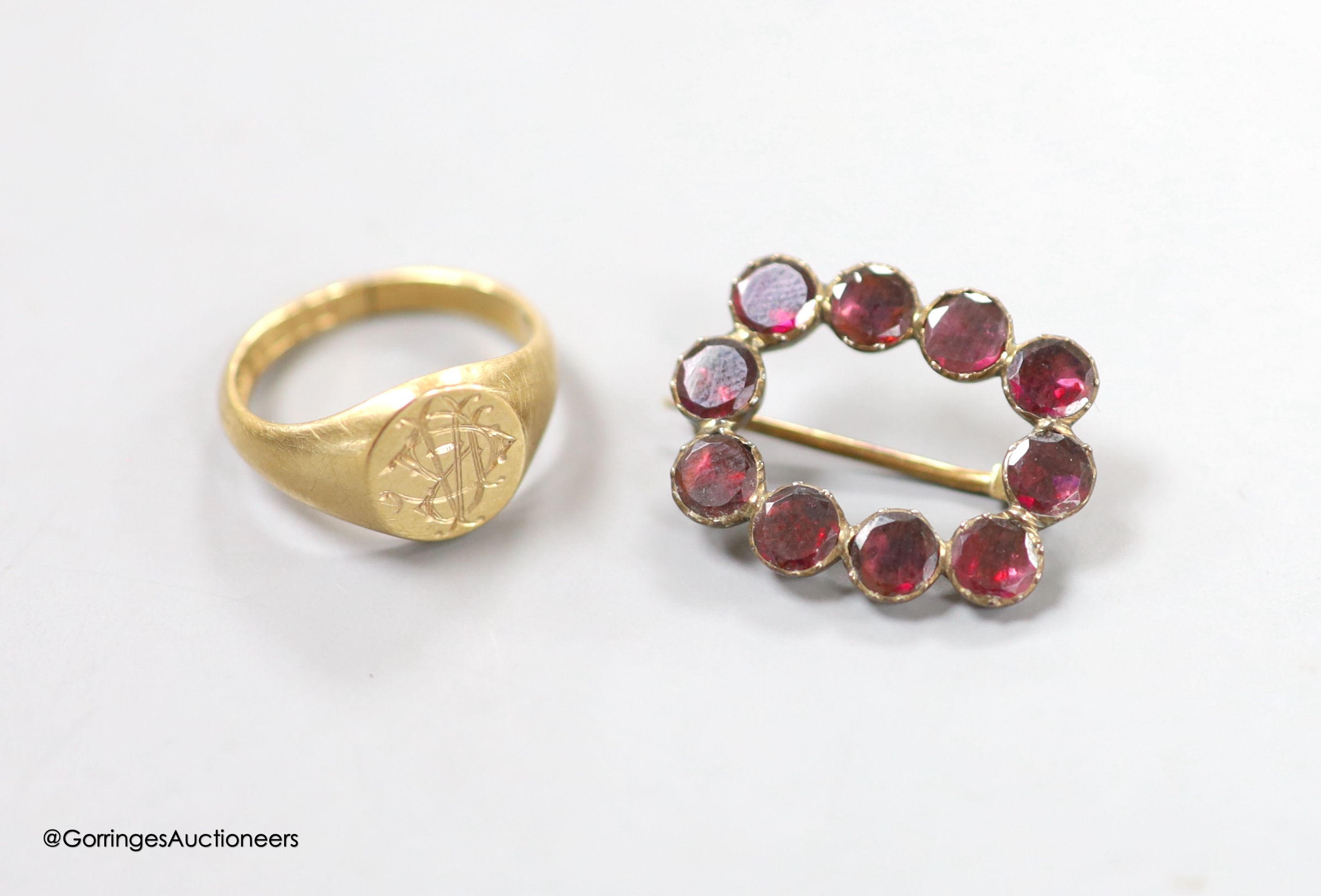 A George V 9ct gold signet ring, size H, 3.6 grams and a Victorian garnet set brooch.